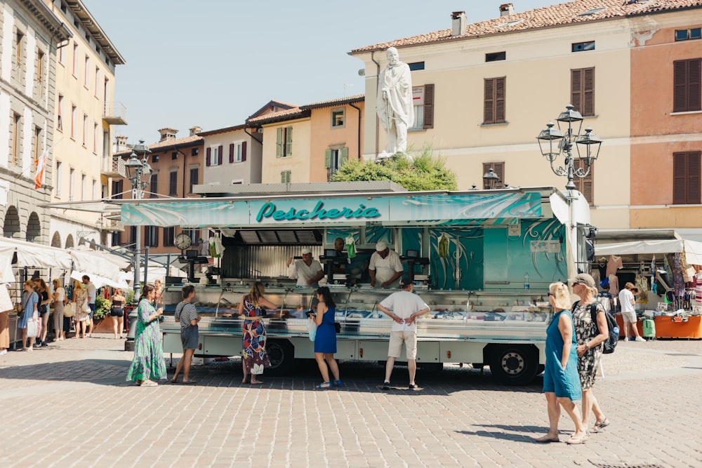 a group of people standing around a food truck