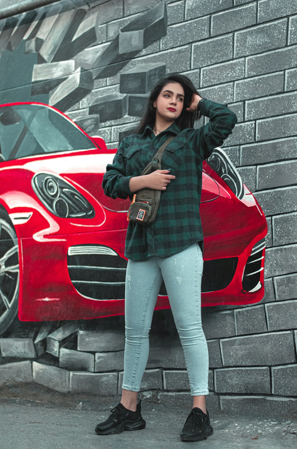 a woman standing in front of a red car