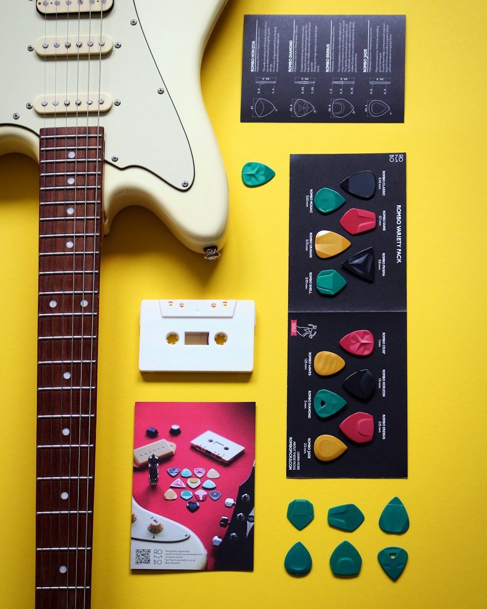 a white guitar, a pair of pickles, and other items on a yellow