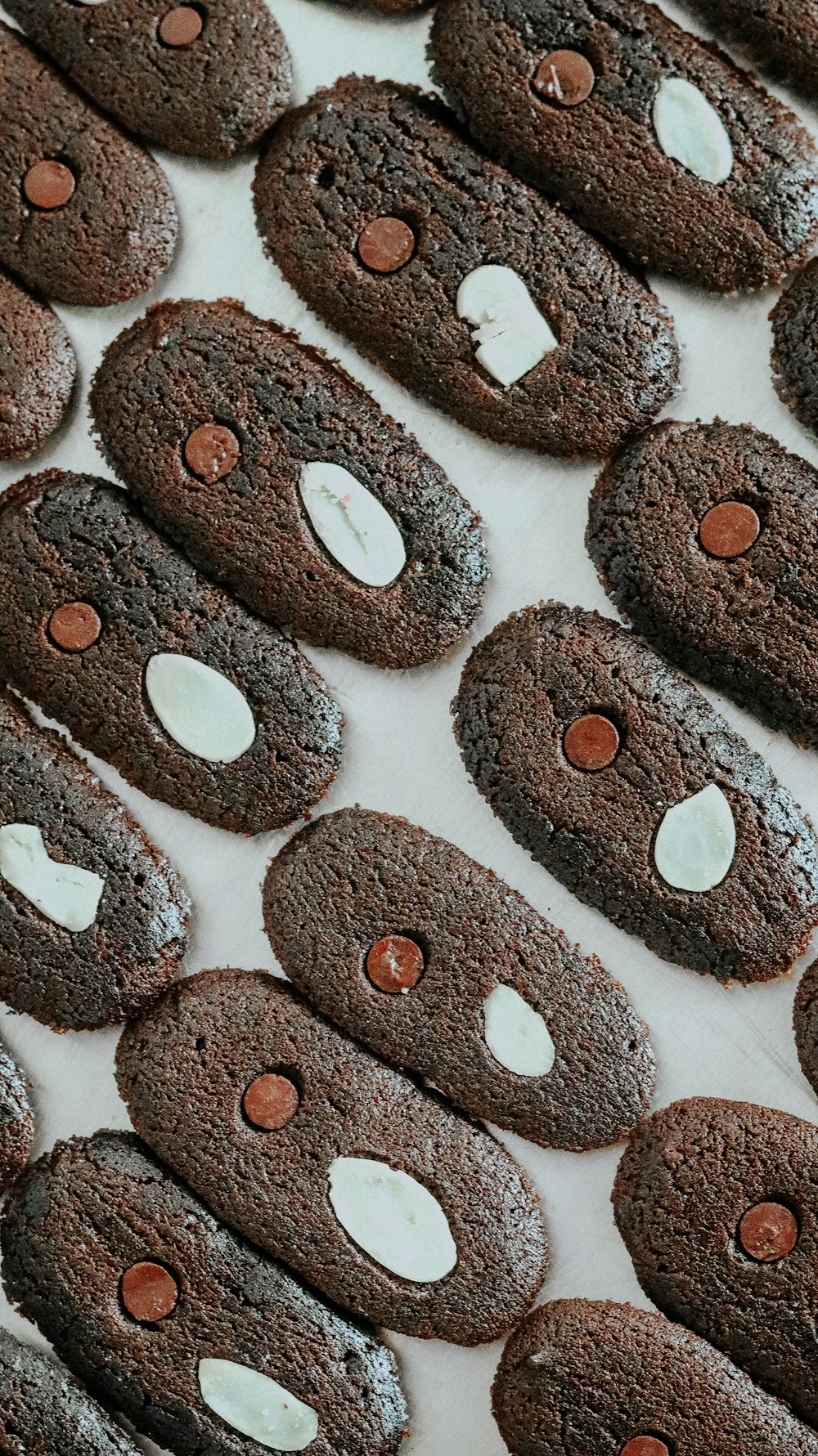 a table topped with chocolate cookies covered in white frosting