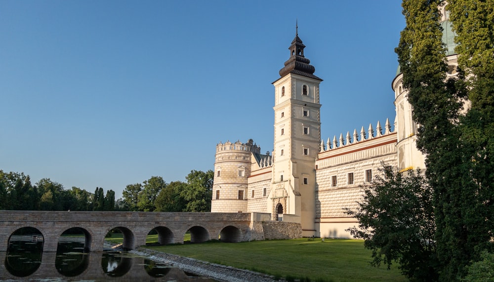 Un gran castillo blanco con un puente frente a él