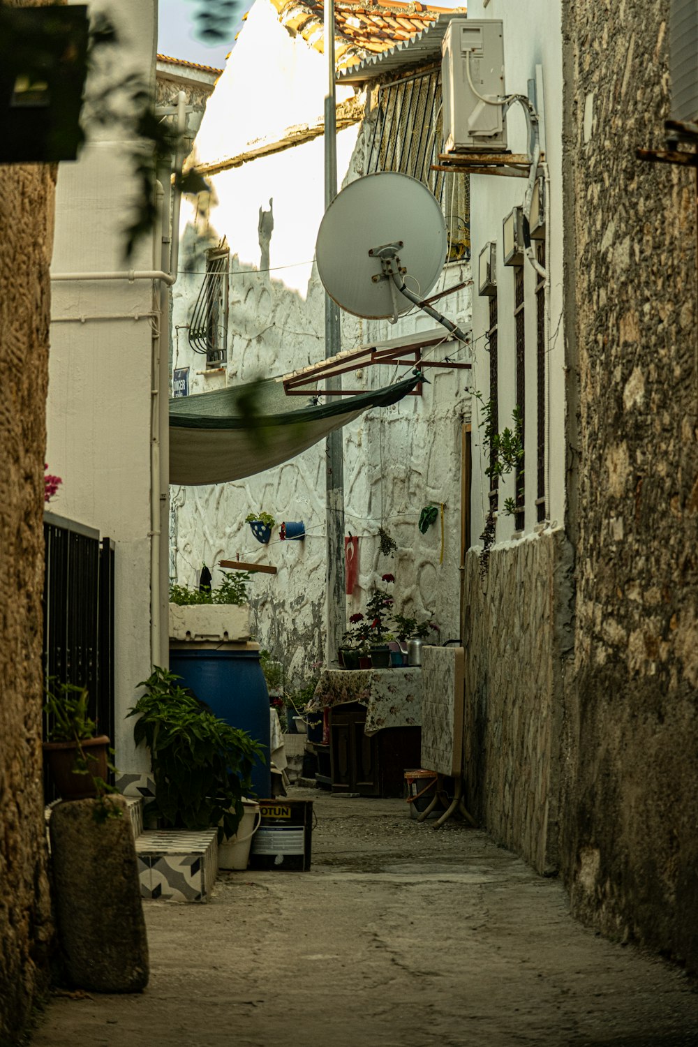 a narrow alley way with a satellite dish on the roof