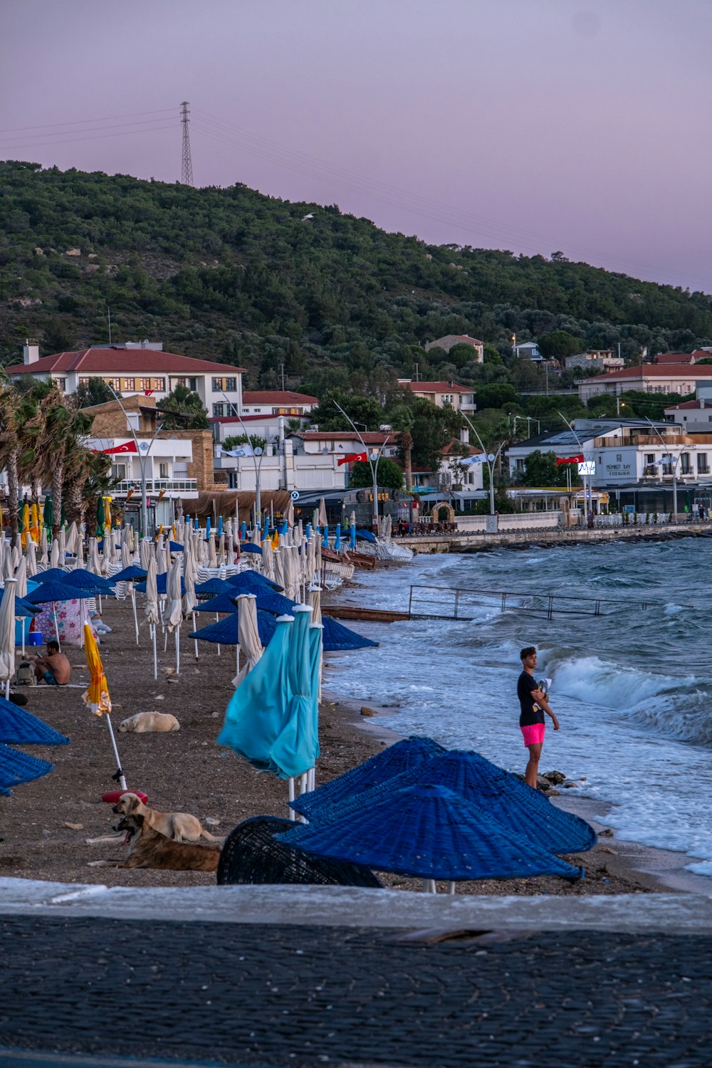 a woman standing on a beach next to a bunch of umbrellas