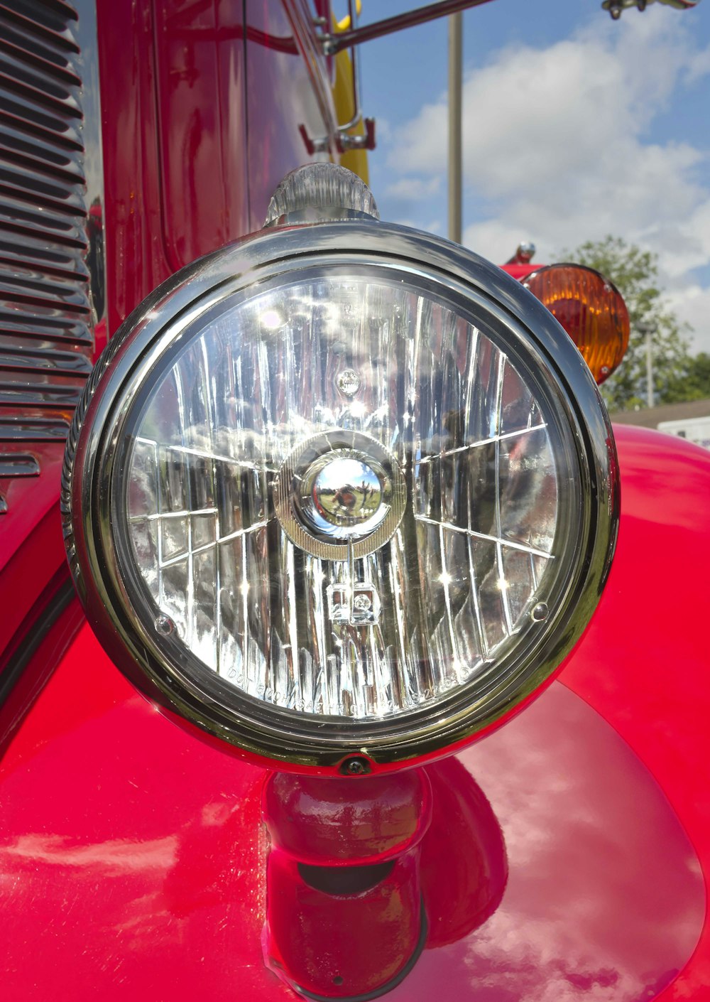 a close up of a headlight on a red truck