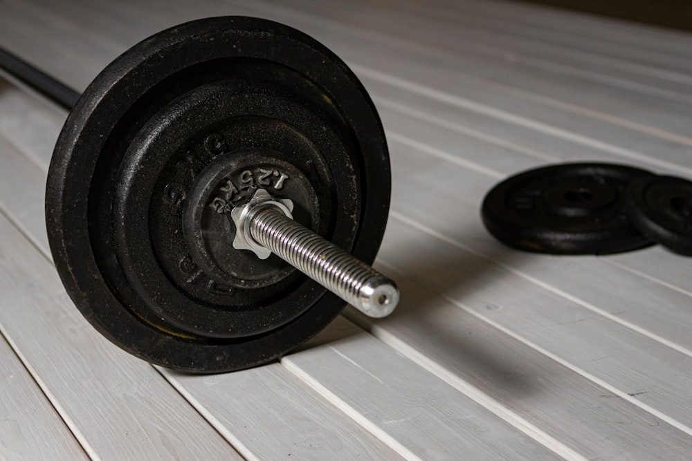 a close up of a barbell on a wooden floor