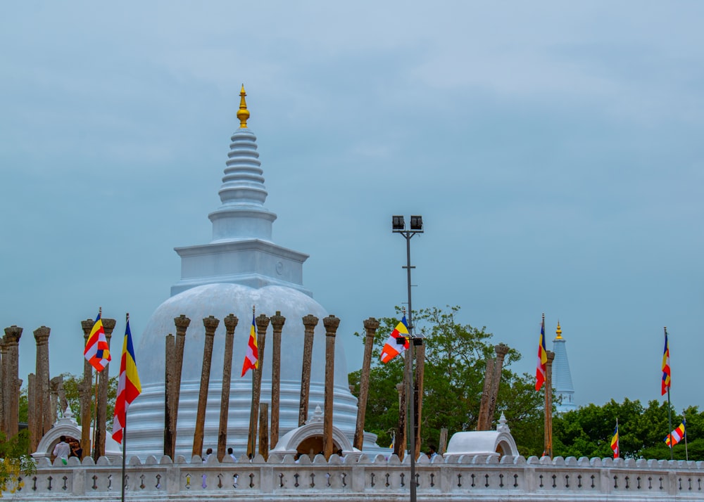 a large white building with many flags around it