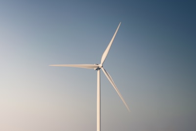 a wind turbine in the middle of a blue sky