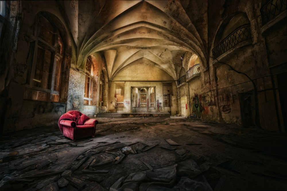 a red chair sitting in an old building