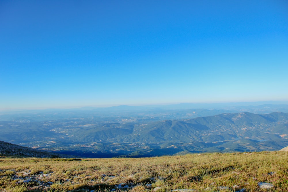 Un uomo in piedi sulla cima di una collina verde lussureggiante