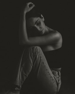 a black and white photo of a woman sitting on the floor