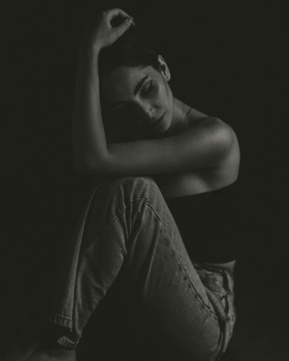 a black and white photo of a woman sitting on the floor