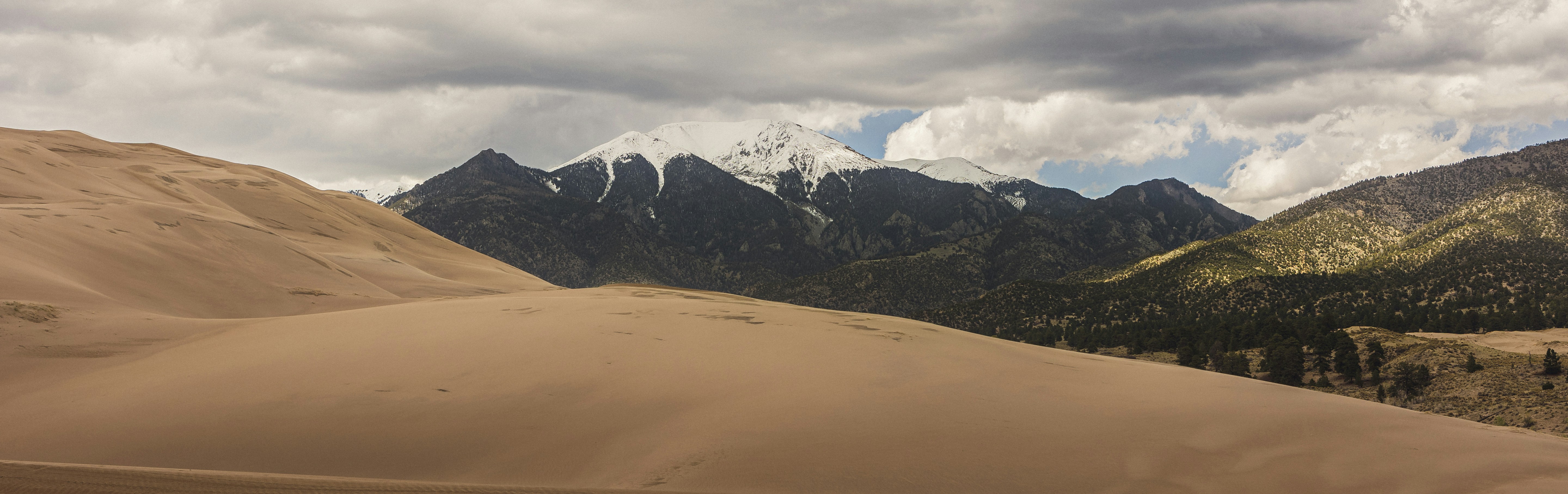 a view of a mountain range from a sand dune