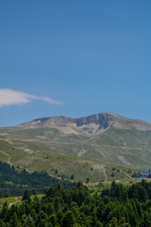 A serene mountain landscape with a clear blue sky.