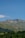 A serene mountain landscape with lush greenery and a clear blue sky.
