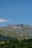 A serene mountain landscape with lush greenery and a clear blue sky.