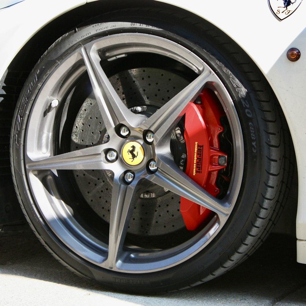 a close up of a ferrari wheel on a white car