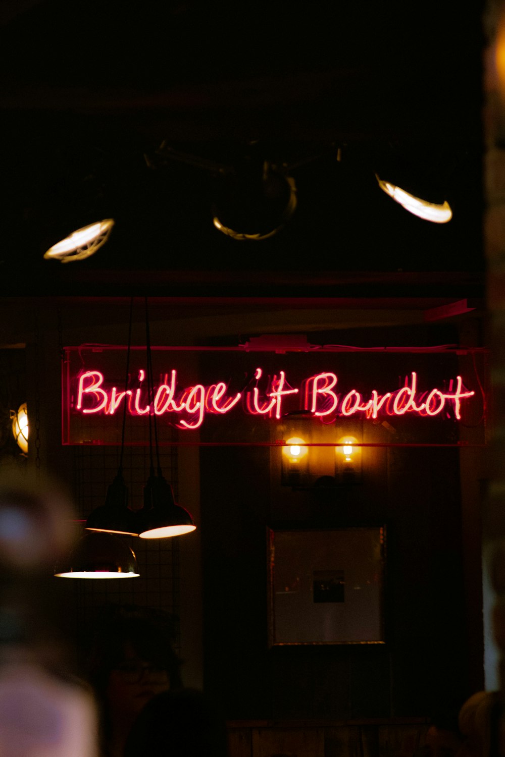 a red neon sign that reads bridge it bandit