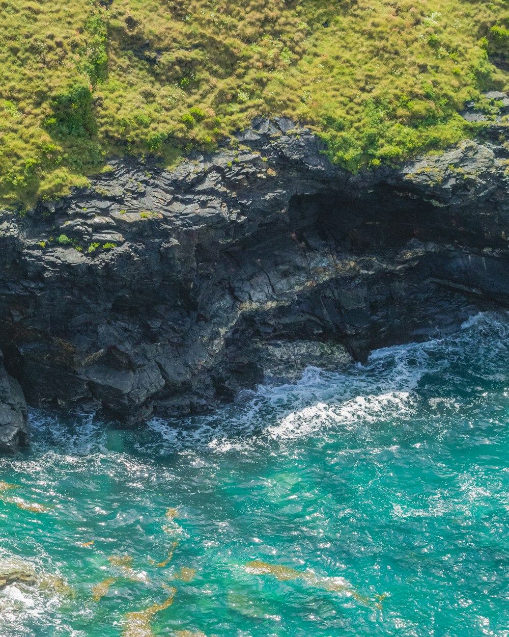 an aerial view of a body of water near a rocky cliff