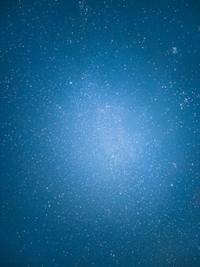 A serene cosmic night sky with shimmering stars and subtle sacred geometry patterns glowing softly.
