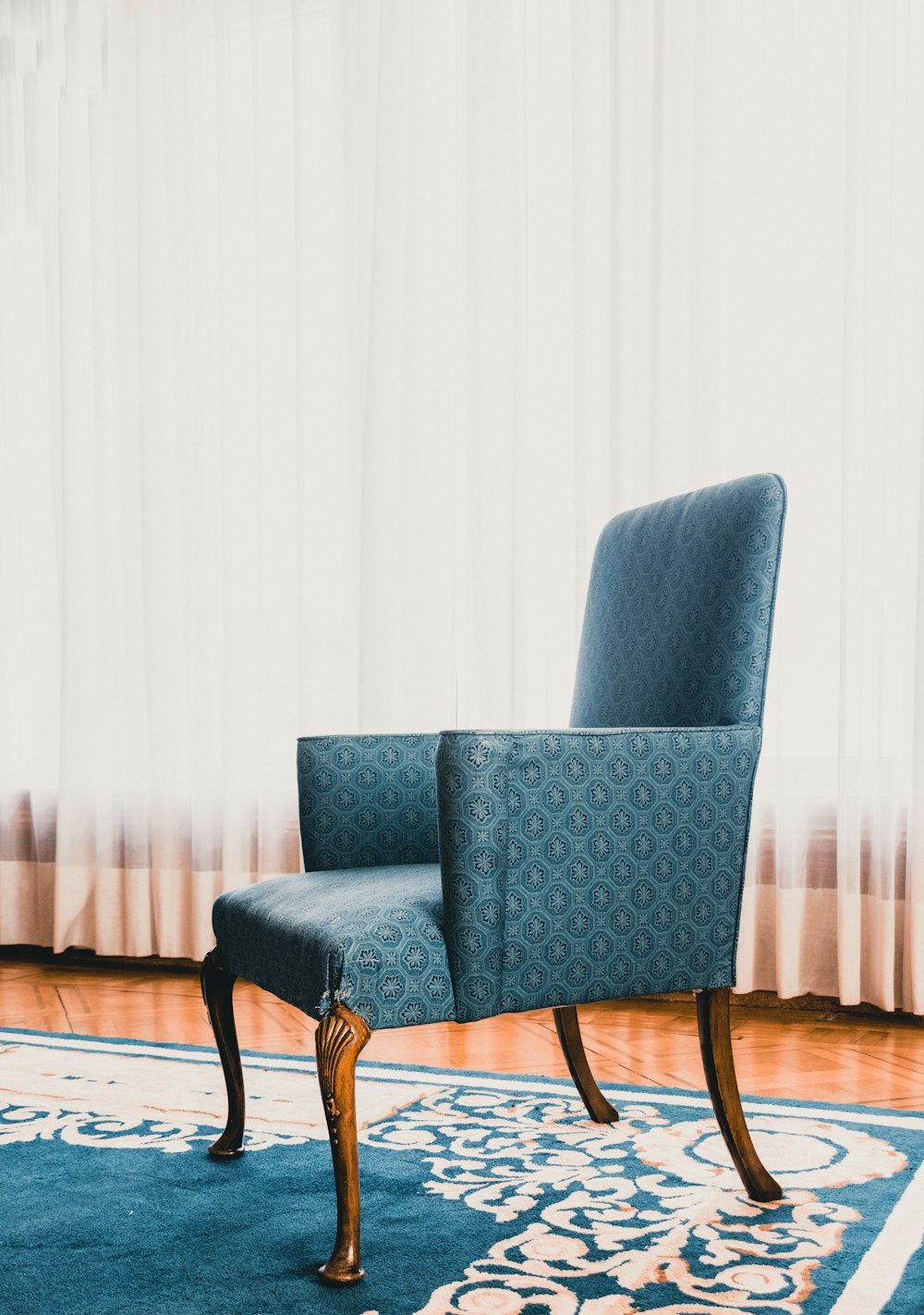 a blue chair sitting on top of a wooden floor