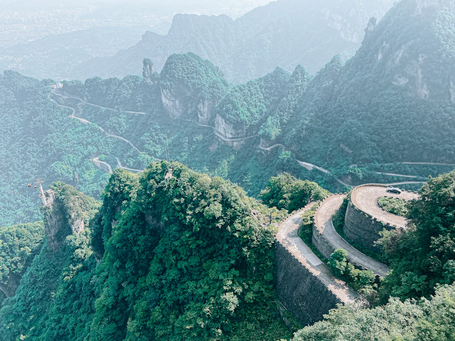 Serpentine 99 bends mountain highway winding down Tianmen Mountain sheer limestone cliffs
