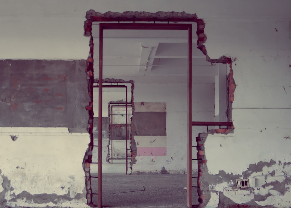 an empty room with a broken mirror in the middle of it