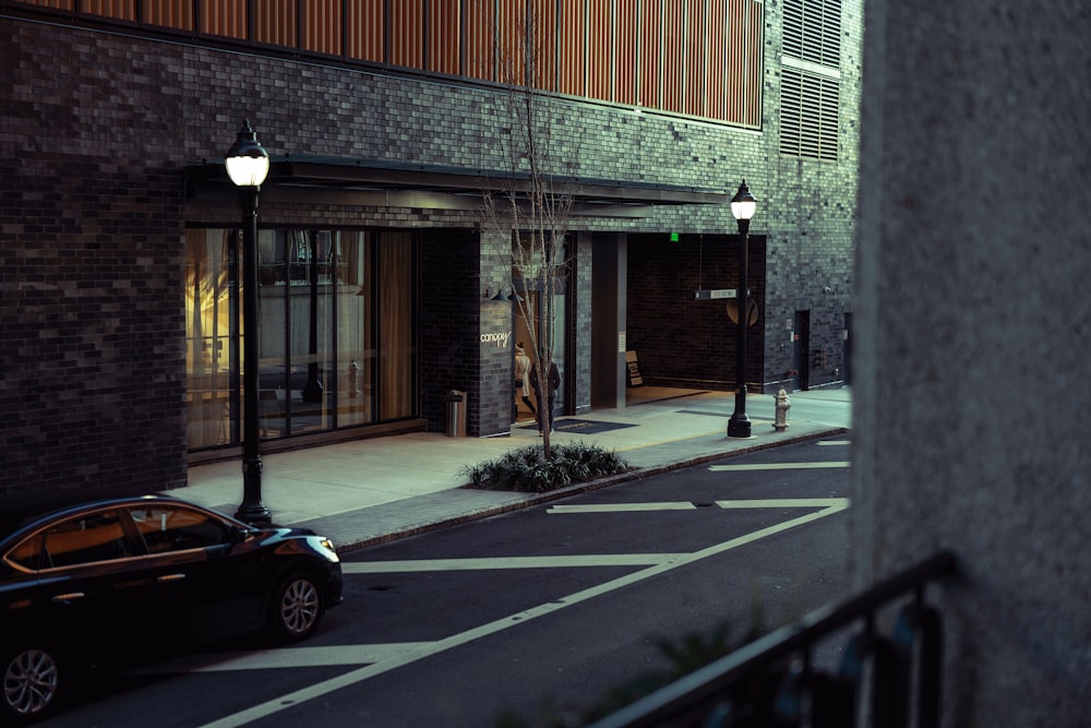 a car parked on the side of a street next to a building