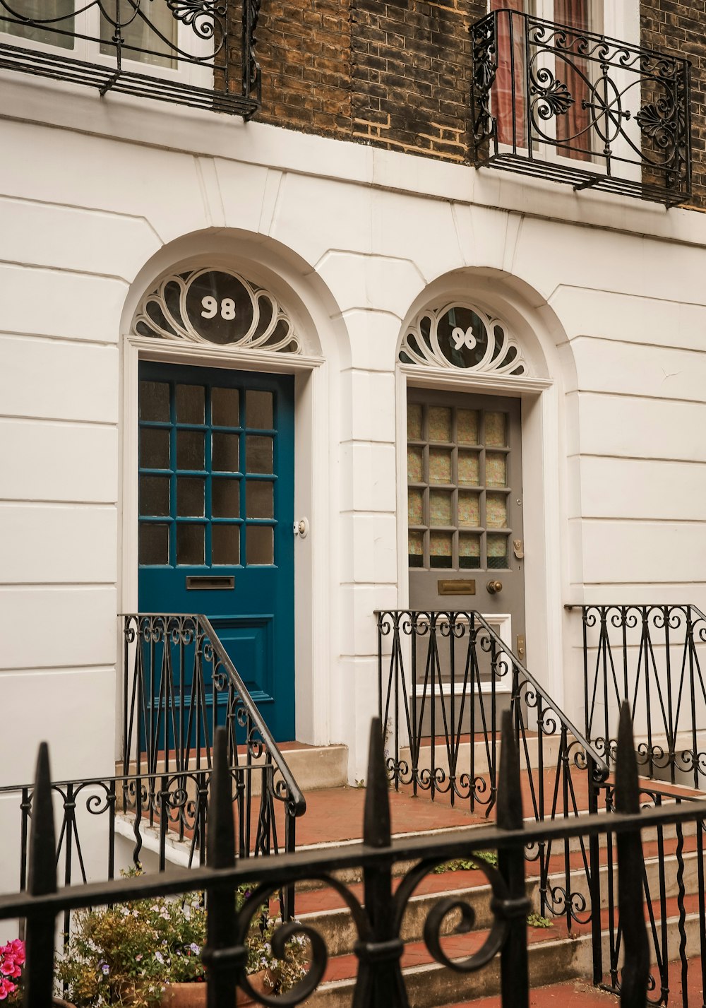 a building with a blue door and wrought iron railing