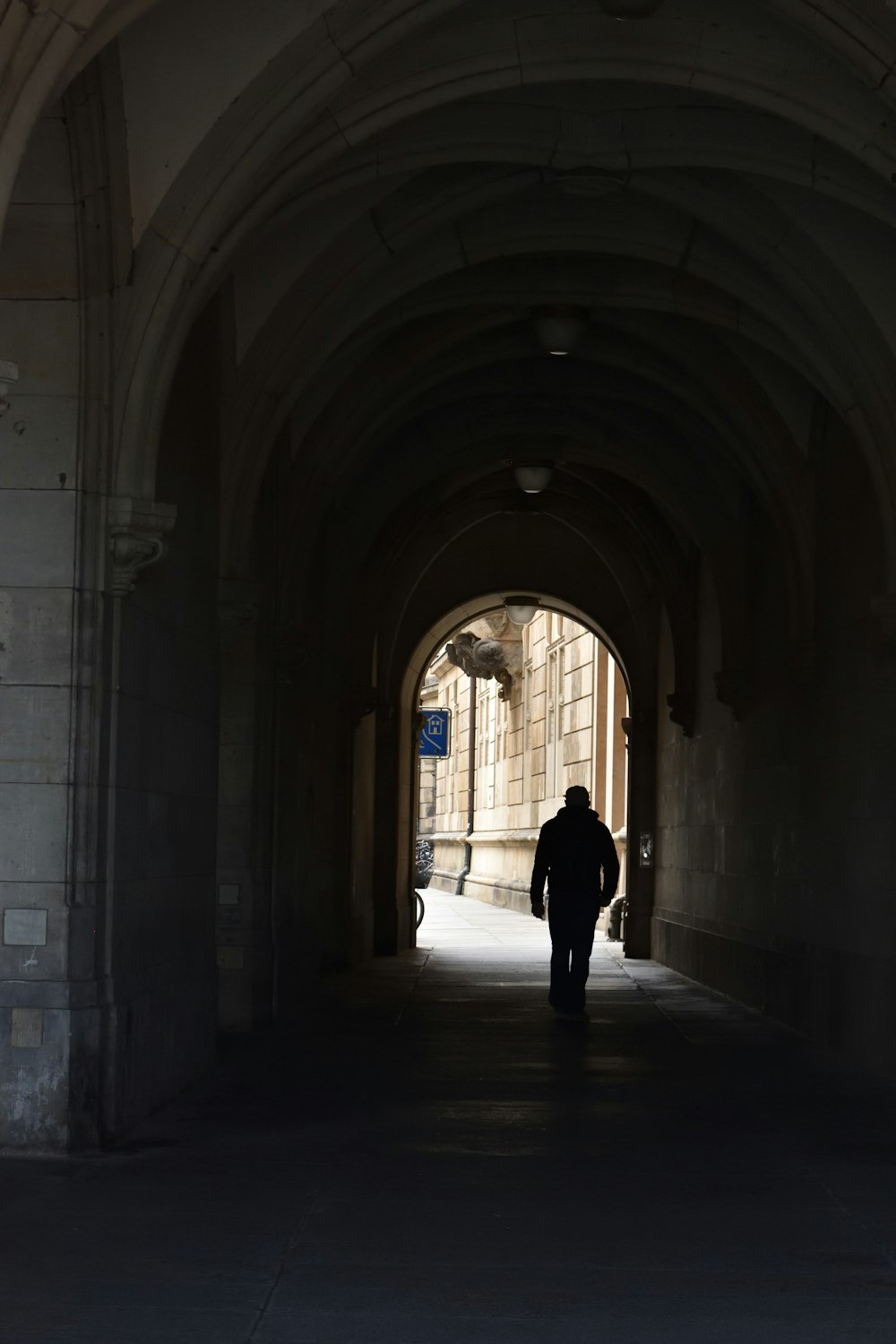 a man is walking down a dark tunnel