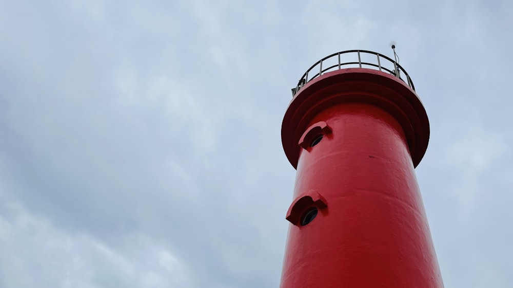 a red light house on a cloudy day