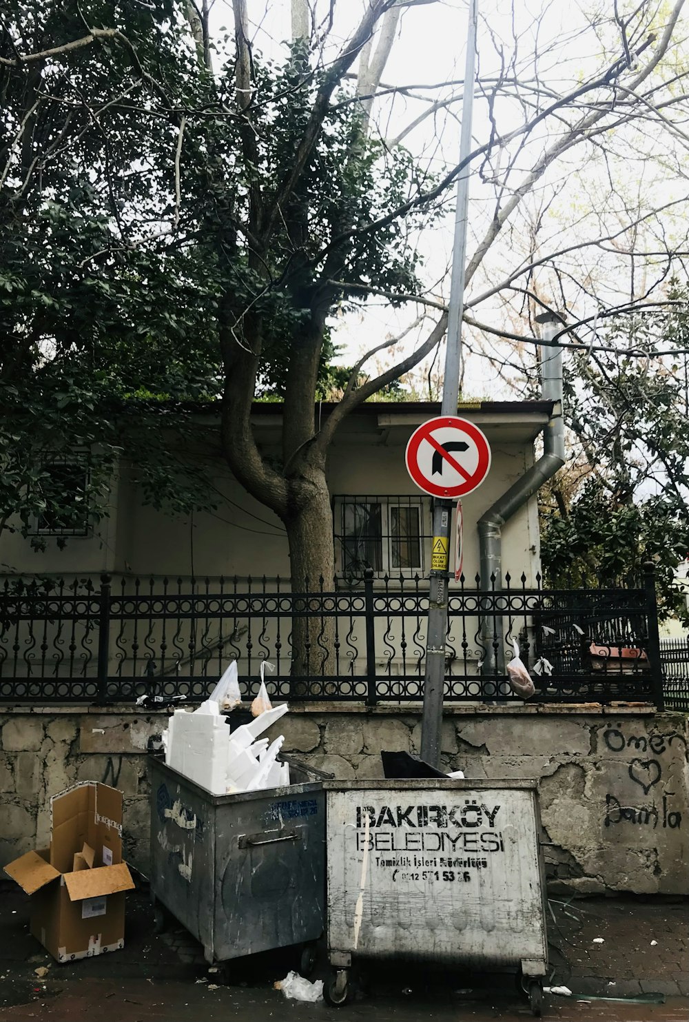 a no right turn sign next to a trash can