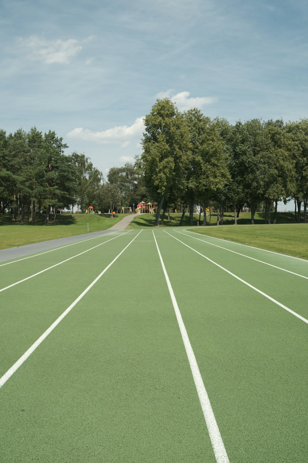 an empty tennis court with trees in the background