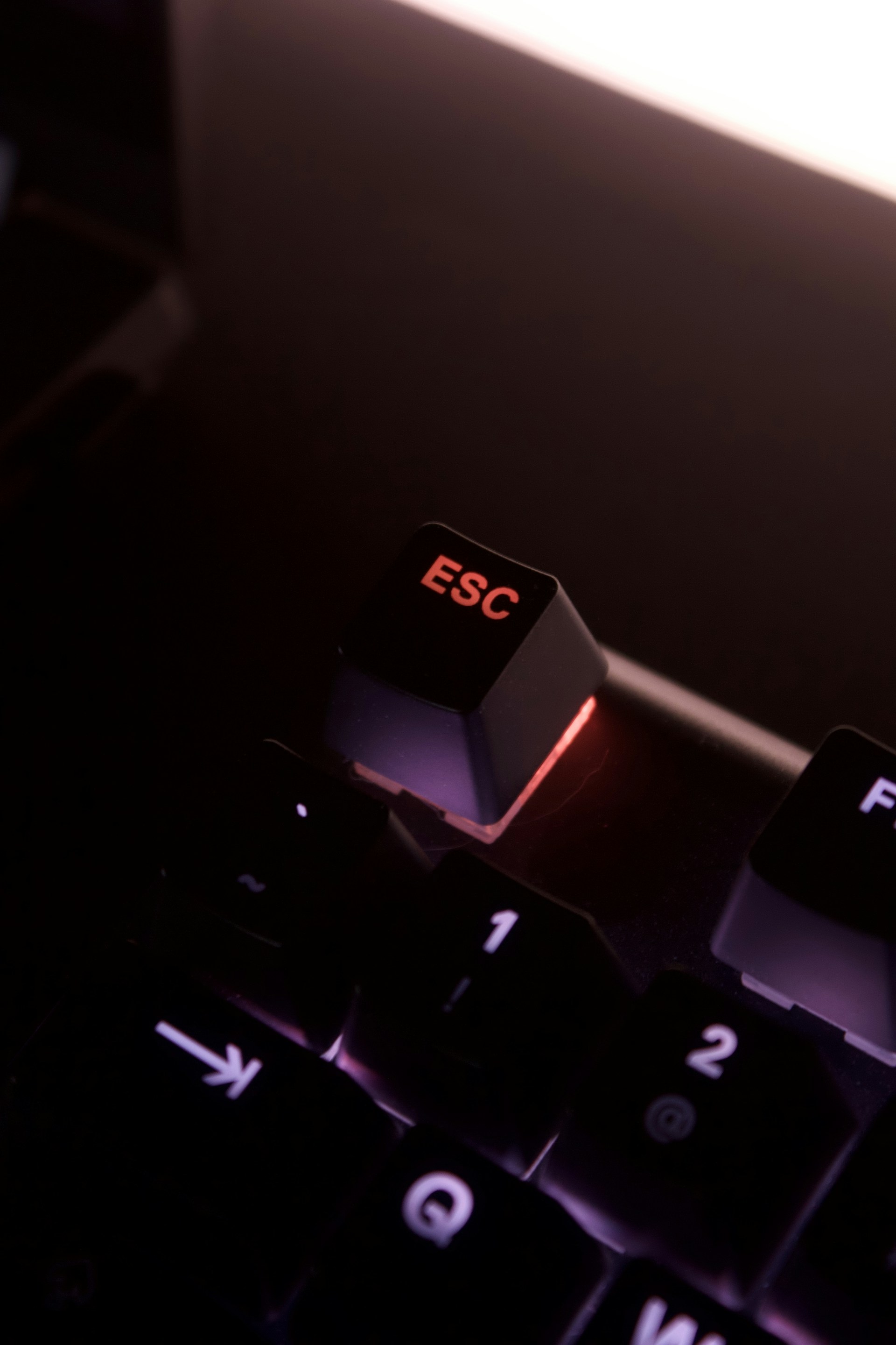 a computer keyboard with a red illuminated key