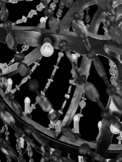 Close-up of a custom-designed chandelier showcasing intricate metalwork and glowing glass elements.