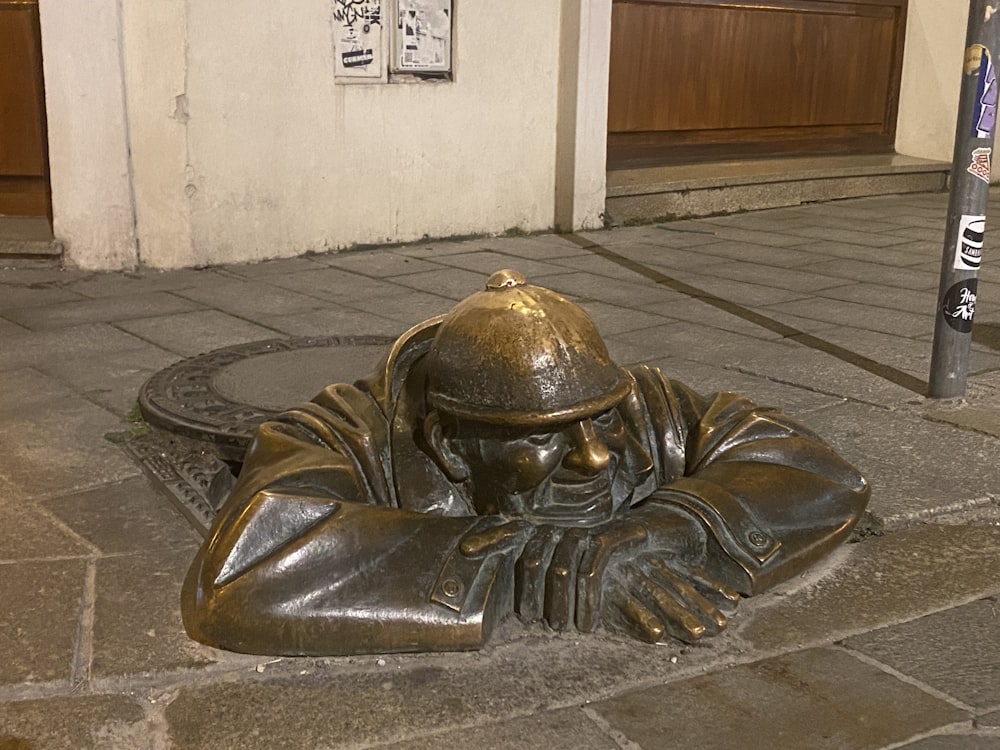 a bronze statue of a man laying on the ground