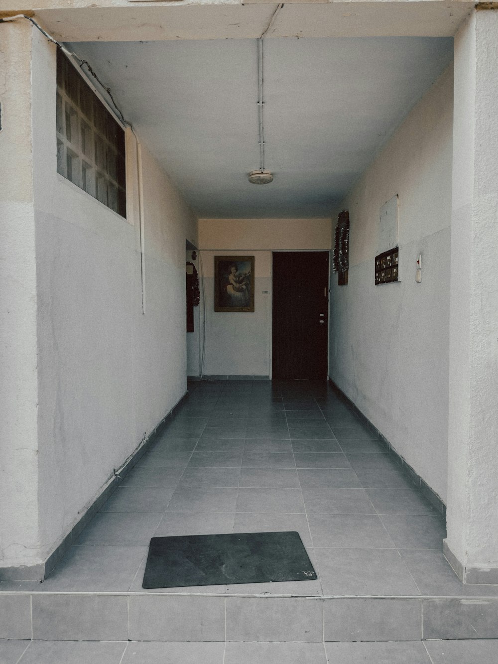 a long hallway with a black door and some pictures on the wall