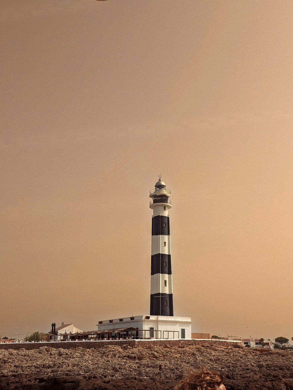 a person laying on the ground in front of a lighthouse