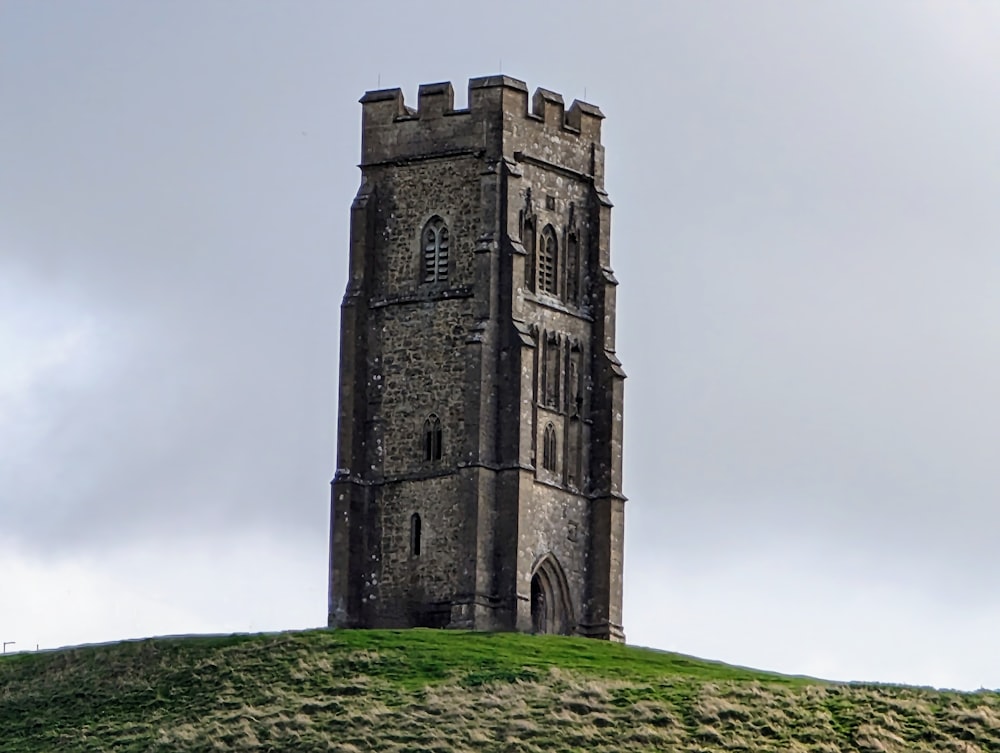 Ein hoher Turm, der auf einem üppig grünen Hügel sitzt