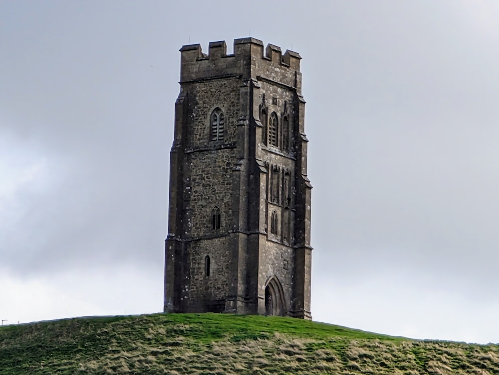 a tall tower sitting on top of a lush green hillside