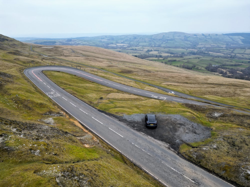 um carro dirigindo por uma estrada sinuosa no meio do nada