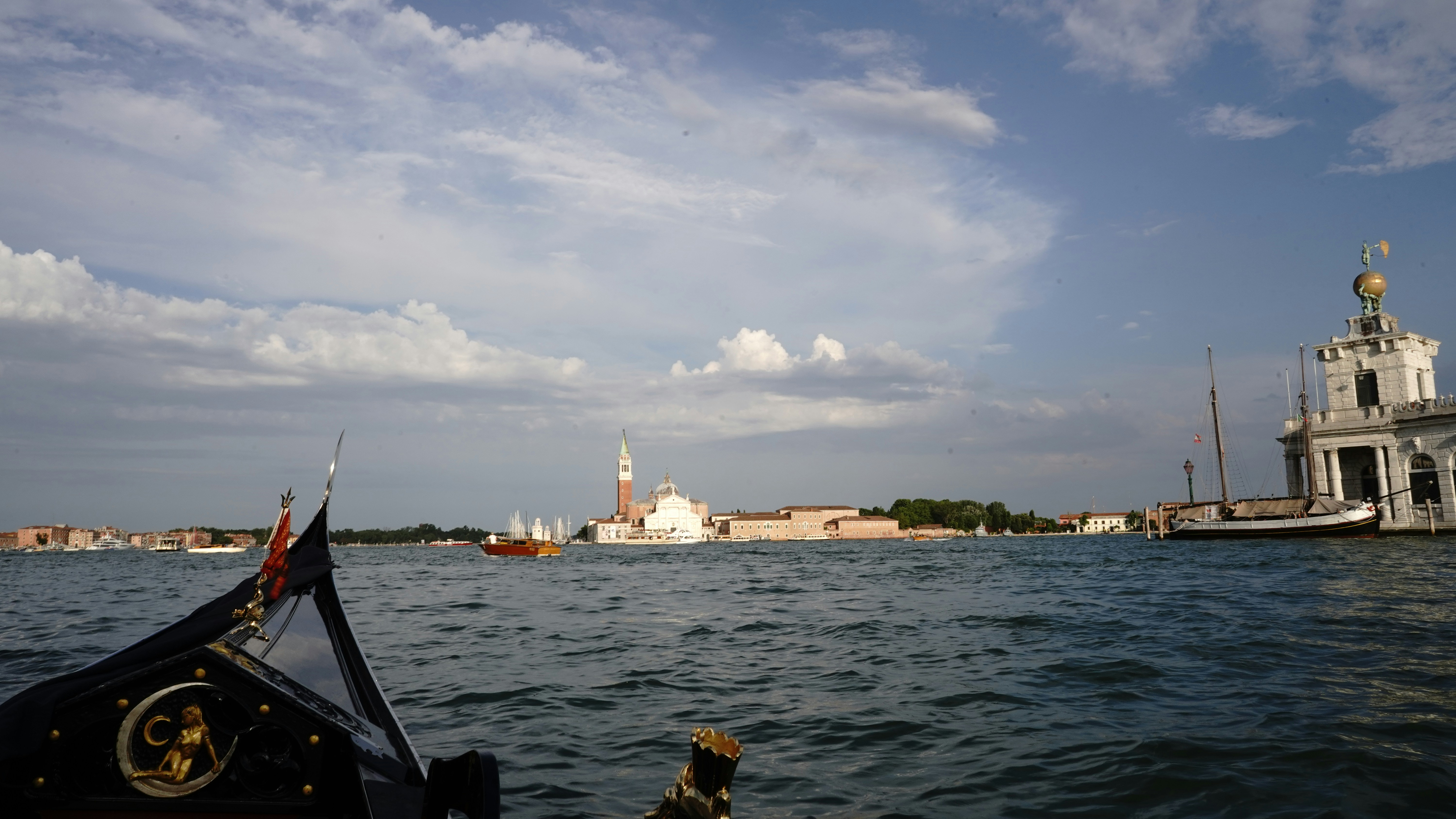 a boat traveling down a river next to a tall white building