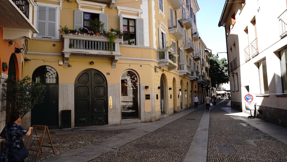 a woman sitting on a chair in front of a yellow building