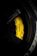 A close-up view of a yellow Nissan branded brake caliper with Brembo carbon ceramic labeling on a car wheel. The surrounding area includes parts of the black rim and tire with some branding visible. The lighting highlights the vibrant yellow of the brake caliper against the darker shades of the wheel.