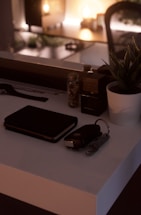 A warm, inviting desk with a notebook, pen, and a small plant beside a softly glowing lamp.