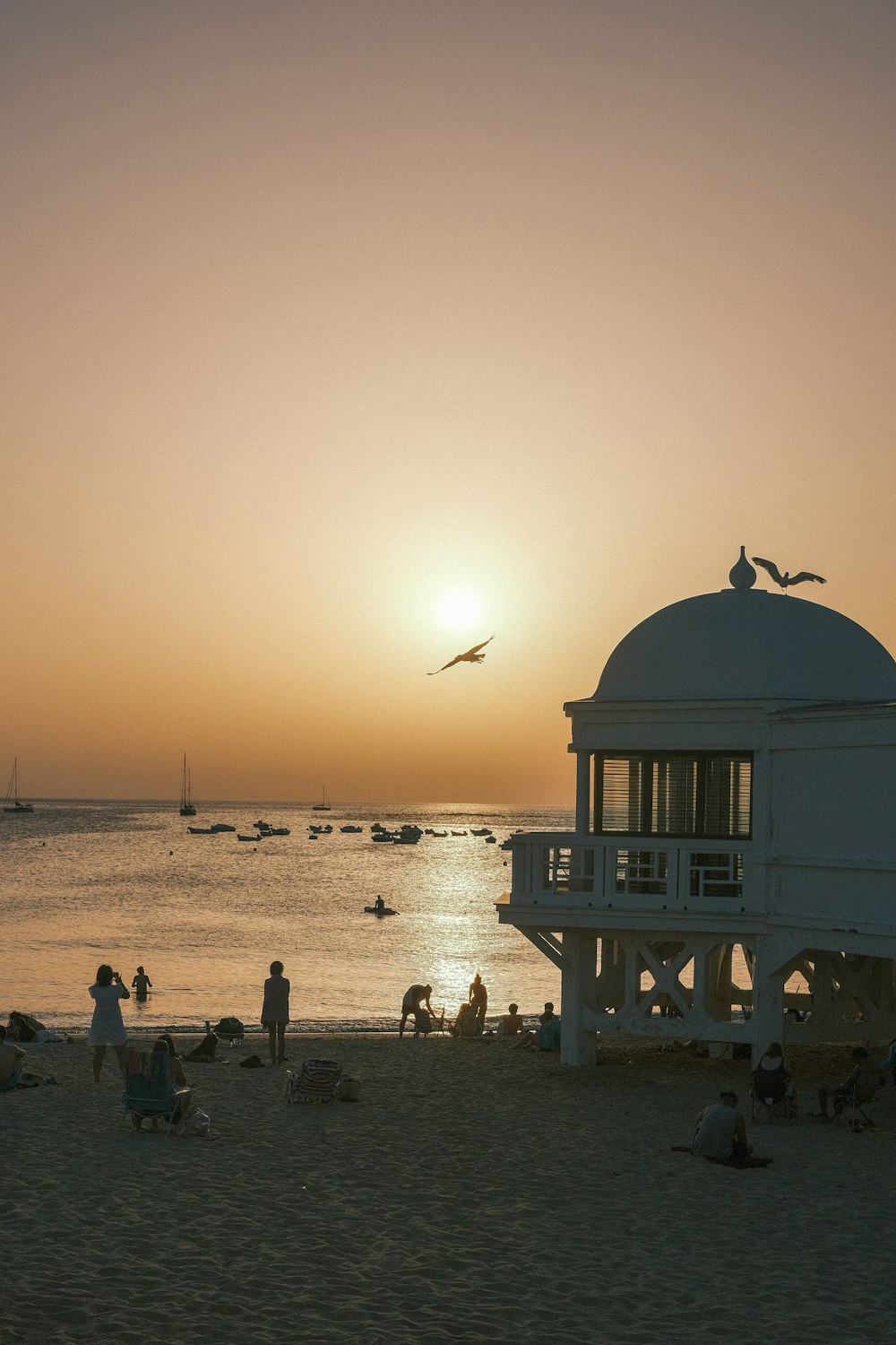 a group of people standing on top of a sandy beach