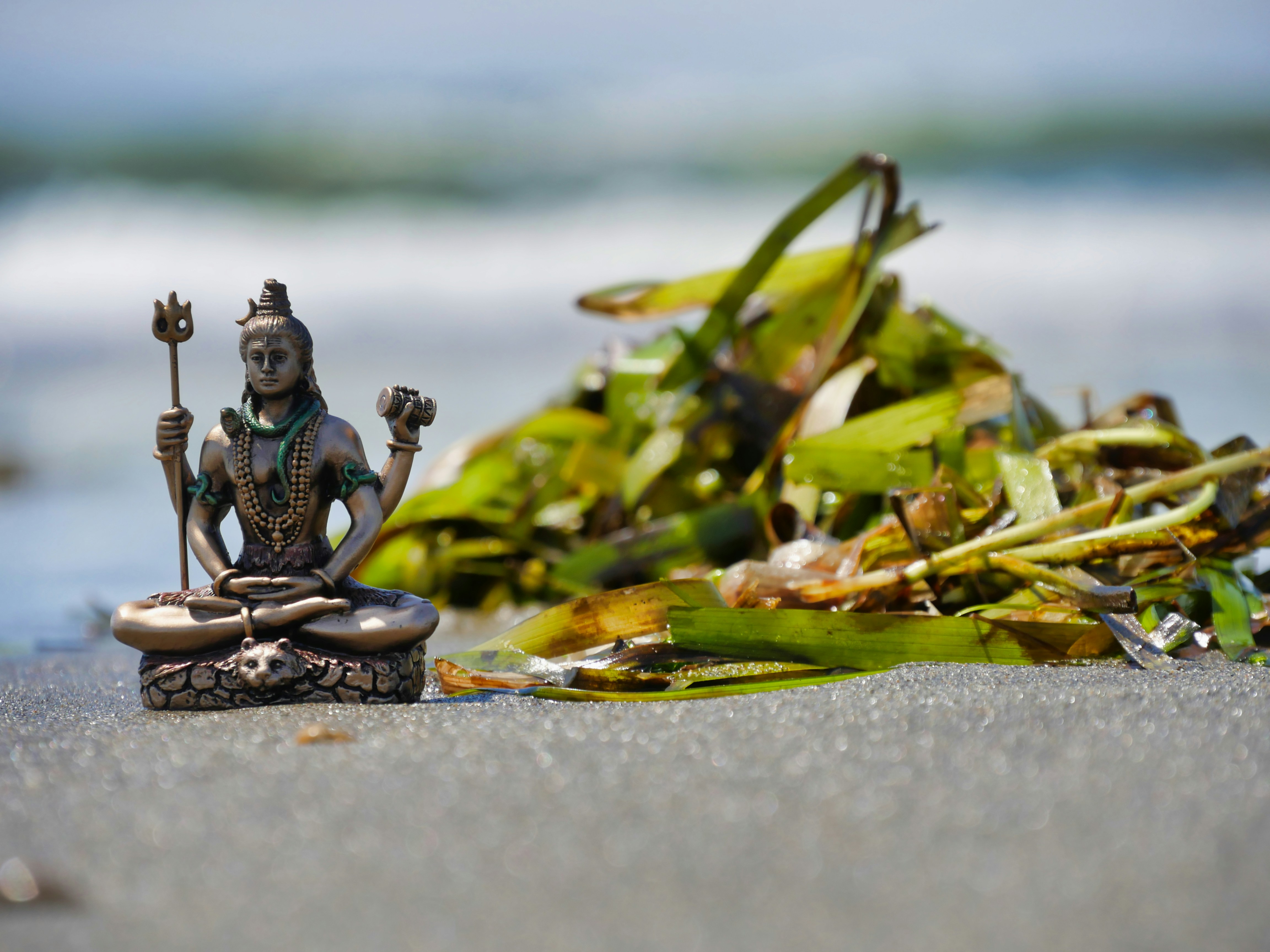a statue sitting on top of a sandy beach