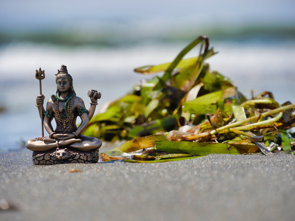 a statue sitting on top of a sandy beach