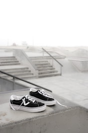Stylish skate shoes on a concrete ledge with graffiti background.
