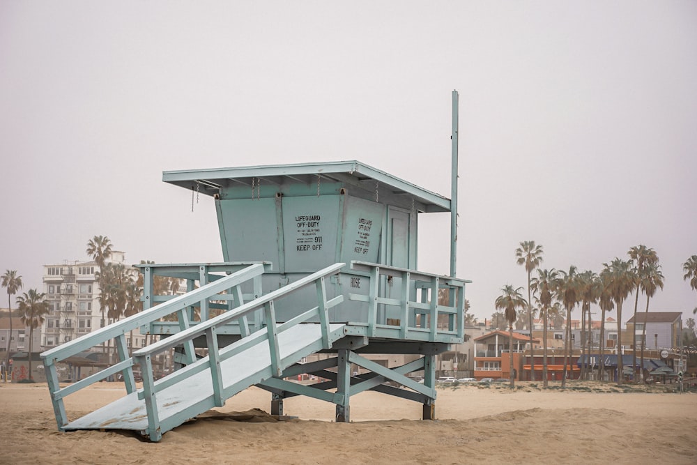 a lifeguard tower sitting on top of a sandy beach