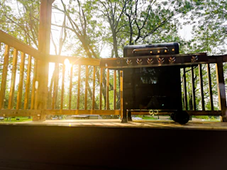 A technician assembling a stainless steel outdoor grill on a sunny patio.
